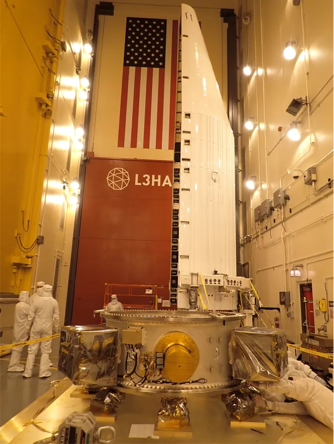 The payload stack positioned beside a launch vehicle fairing half ahead of mating to the payload attach fitting.